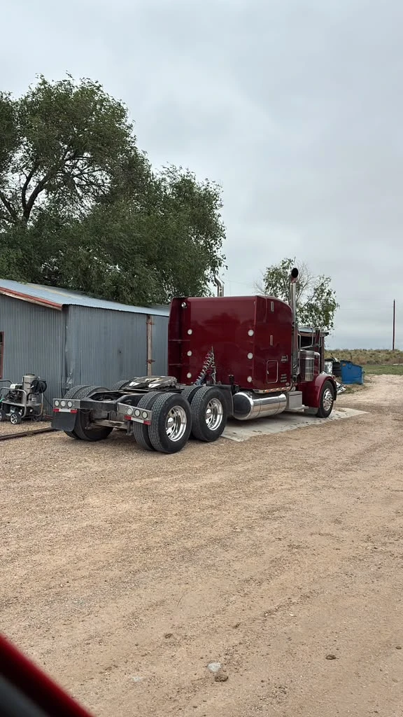 Maroon Peterbilt semi truck day cab at the shop